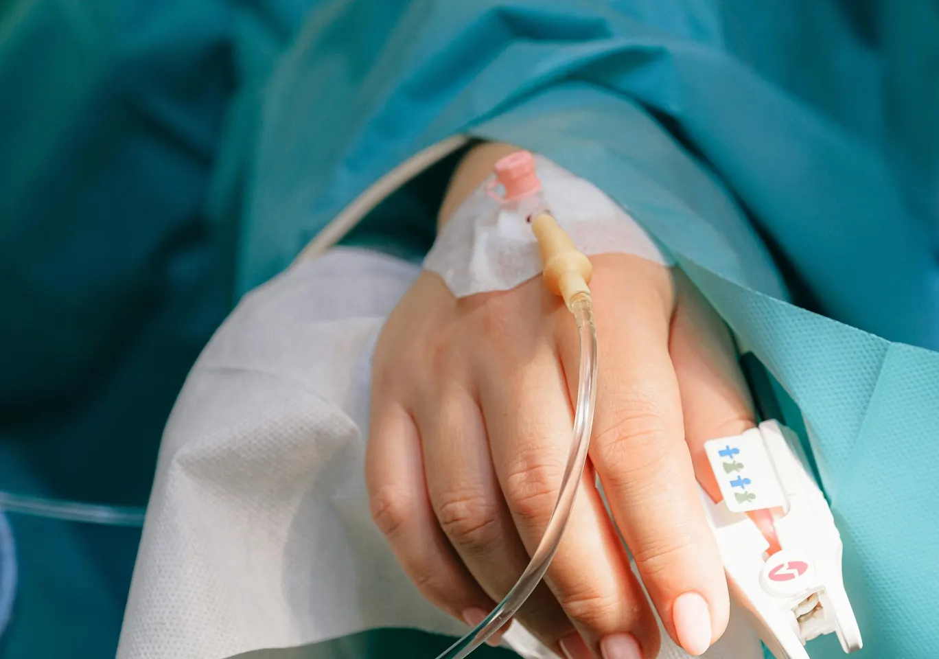 Detoks alkoholowy Karpacz: dłoń z wenflonem i pulsoksymetrem pod nadzorem