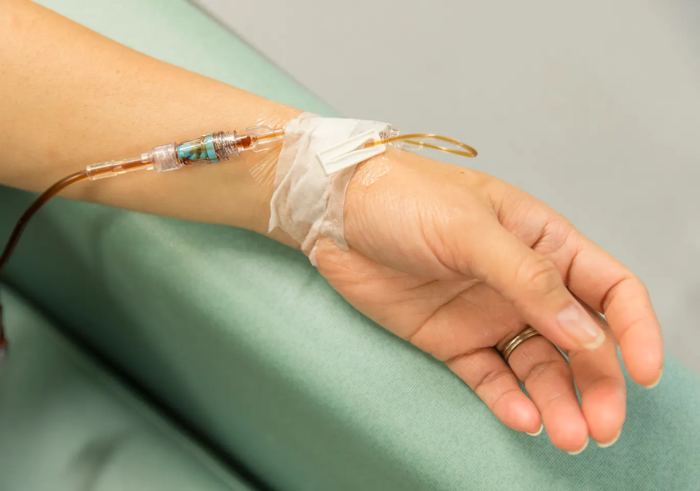 Kroplówki witaminowe Jelenia Góra: dłoń z wenflonem i linią infuzyjną na podkładzie